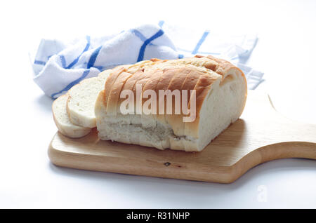 Loaf of sliced italian white bread on wood cutting board Stock Photo