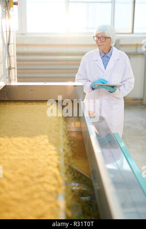 Senior Woman in Food Factory Workshop Stock Photo