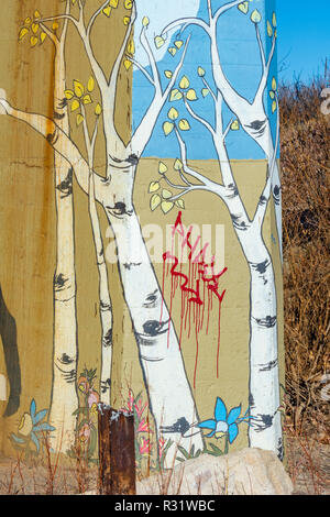 Colorful painting of Aspen trees on concrete bridge support of railroad bridge defaced by graffiti. Castle Rock Colorado US. Photo taken in November. Stock Photo