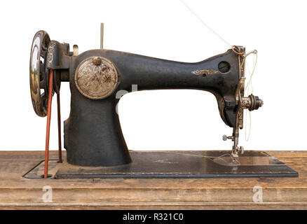 An Isolated Antique Sewing Machine On A Wooden Table With A White Background Stock Photo