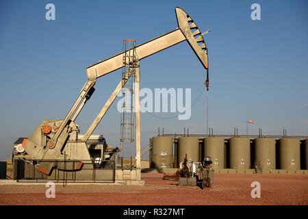 Crude oil pump jack and production storage tanks in the Powder River Basin. Stock Photo