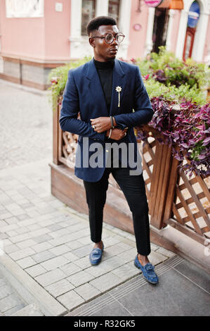 Amazingly looking african american man wear at blue blazer with brooch,  black turtleneck and glasses posed at street. Fashionable black guy sitting  behind table with mobile phone. 10463184 Stock Photo at Vecteezy