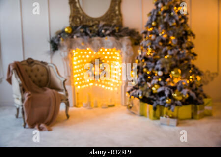 Blured christmas interior background with artificial fireplace and New Year Tree decorated for holiday Stock Photo
