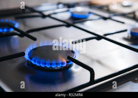 Gas kitchen stove cook with blue flames burning. Panel from steel with a gas Stock Photo