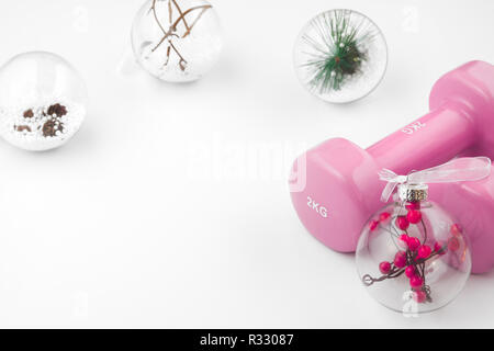 Pink Dumbbells and Christmas ornaments decoration on white background. Fitness Workout Chirstmas background concept. Stock Photo