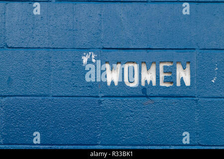 Simple White on black women text cut into blue concrete blocks. Stock Photo