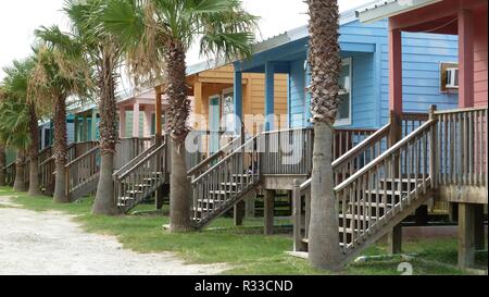 Row of small colorful wooden beach houses and palm trees on the coast of the Gulf of Mexico Stock Photo