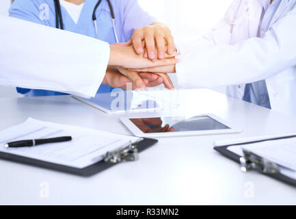 Group of doctors joining hands at meeting. Teamwork and success in medicine Stock Photo