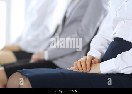Business people waiting for job interviews or taking part at conference in office, close-up. Women sitting on chairs like at queue or meeting Stock Photo