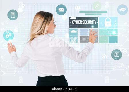 back view of businesswoman in eyeglasses pointing at cyber security signs isolated on white, information security concept Stock Photo