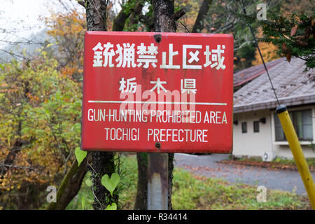 A red Japanese No Gun Hunting sign in Nikko, Japan. Stock Photo