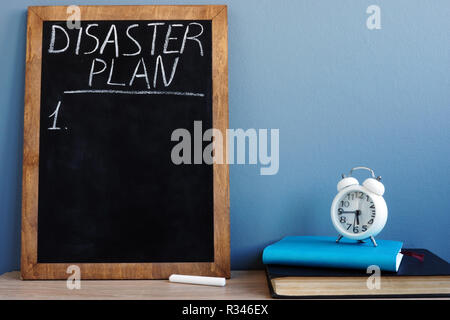 Disaster Plan written on a blackboard and notepads. Stock Photo