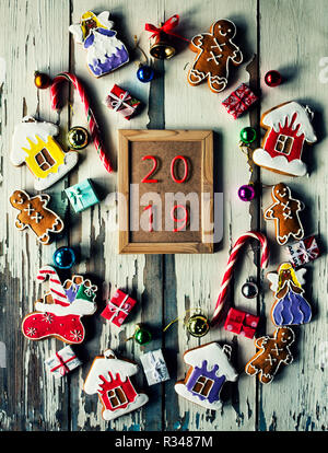 2019. Christmas gingerbread. Christmas baking on a wooden background with burning candles. Concept of the New Year 2019 Stock Photo