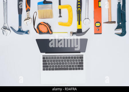 top view of laptop with different tools lying on white Stock Photo