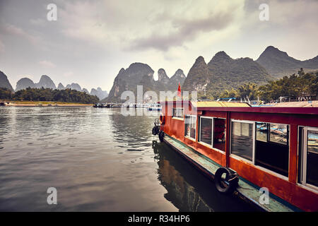 Retro toned picture of boats moored at the Lijiang River bank in Xingping. Lijiang River cruises are amongst the top China travel destinations. Stock Photo