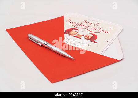 Christmas card for Son and Daughter in Law with red envelope and pen on white background Stock Photo