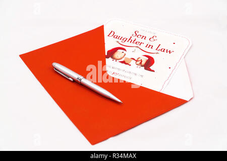 Christmas card for Son and Daughter in Law with red envelope and pen on white background Stock Photo