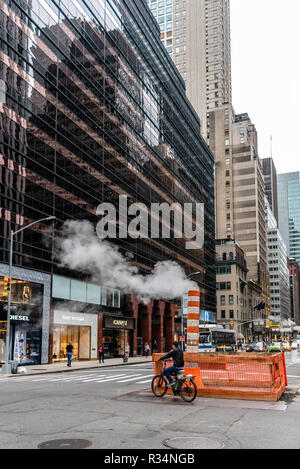 New York City, USA - June 24, 2018: Steam coming out stack for venting the district heating system in Midtown of New York Stock Photo