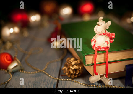 A Christmas deer toy sits on books Stock Photo