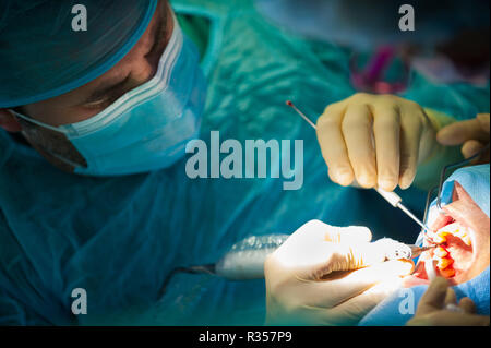 Dentist in the operational theatre working on a patient, one person Stock Photo