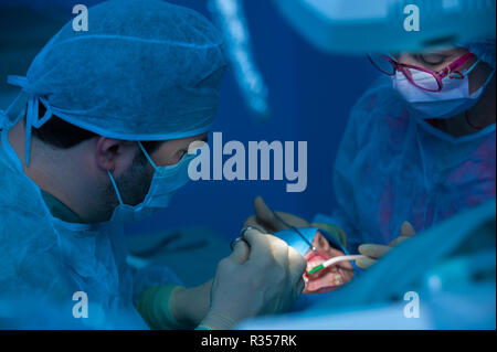 Dentist and assistant working in cooperation in the operational theatre Stock Photo
