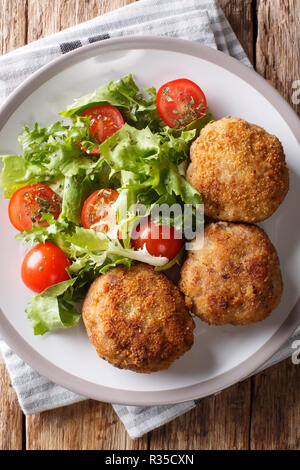 Danish Breaded Pork Patties Karbonader served with fresh salad close-up on the table. Vertical top view from above Stock Photo