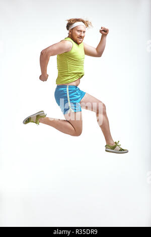 Red haired, bearded, plump man jumps in sportswear Stock Photo