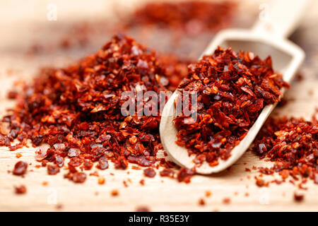 Dried ground red pepper and seeds on wooden background Stock Photo