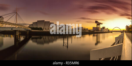 A stunning panoramic sunrise view across the River Clyde reflecting the Bell's Bridge, Armadillo, Hydro Arena, Finnieston Crane and Clyde Arc Bridge. Stock Photo