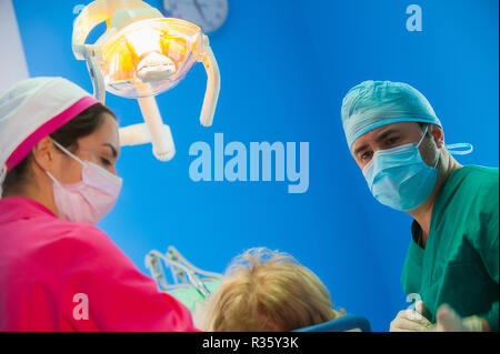 Dentist and assistant working in cooperation in the operational theatre Stock Photo