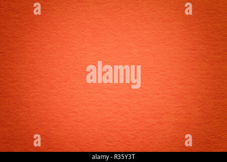 Texture of vintage dark red paper background with vignette. Structure of dense orange kraft cardboard with frame. Felt gradient backdrop closeup. Stock Photo