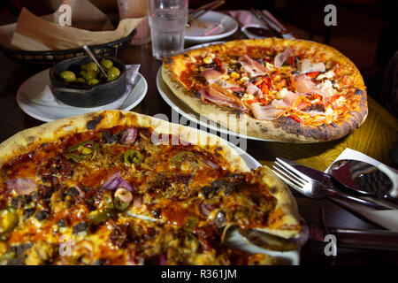 Pizzas on a table in a pizza restaurant. Stock Photo