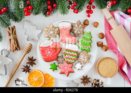 Holiday food background. Gingerbread cookies with cutters, rolling pin and ingredients for baking on white wooden table. Top view. Stock Photo