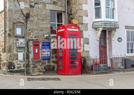 Traditional iconic British red telephone box in a street in Cornwall, England Stock Photo