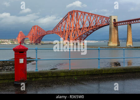 The Forth Rail Bridge from South Queensferry with Victorian red post box in foreground. South Queensferry, Edinburgh, Scotland Stock Photo