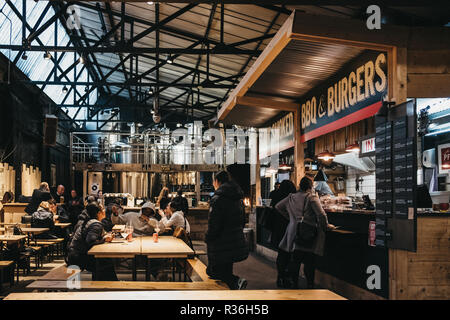 London, UK - November 2, 2018: People by BBQ and burger stand in Mercato Metropolitano, the first sustainable community market in London focused on re Stock Photo