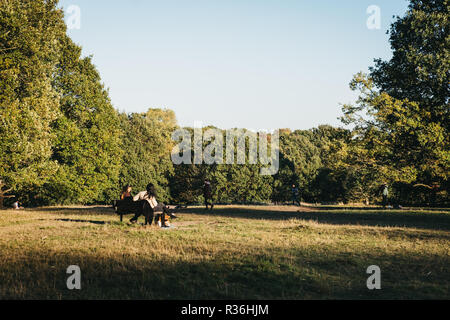 London, UK - October 27, 2018:People sitting on a bench, relaxing on a sunny day in Hampstead Heath. Hampstead Heath covers 320 hectares one of London Stock Photo