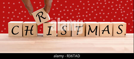 The word "CHRISTMAS" on dices infront of a red background Stock Photo