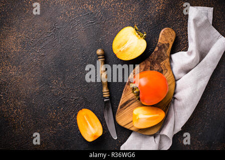 Fresh ripe persimmon on cutting board Stock Photo
