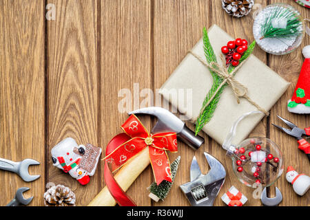 Merry Christmas Handy Tools Christmas Gift concept. Hammer, adjustable wrenches, wrenches, pliers, gift box and Christmas ornament decorations on wood Stock Photo