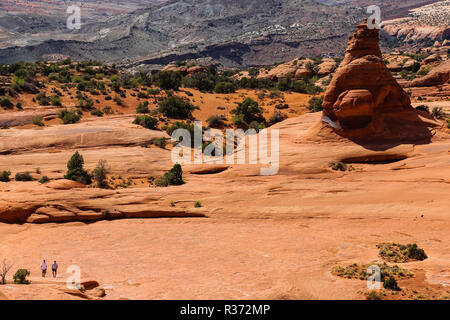 two people hiking in arches national park in the utah desert Stock Photo