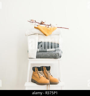 Warm clothing, blankets, boots and cap on chair, square crop Stock Photo