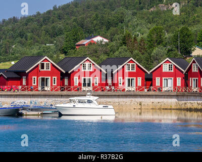 Typical red-white wooden holiday cottages, pier with leisure boats,  Lyngen,Lenangsstraumen,  Lyngen peninsula Stock Photo