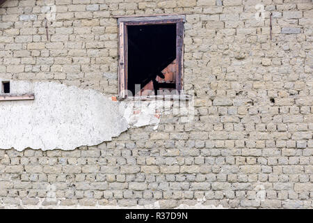 Old abandoned building facade wall with empty window Stock Photo