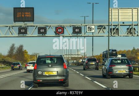 BRISTOL, ENGLAND - NOVEMBER 2018: Traffic passing under a gantry on the M4 motorway near Bristol. The electronic signs are showing the setting for the Stock Photo