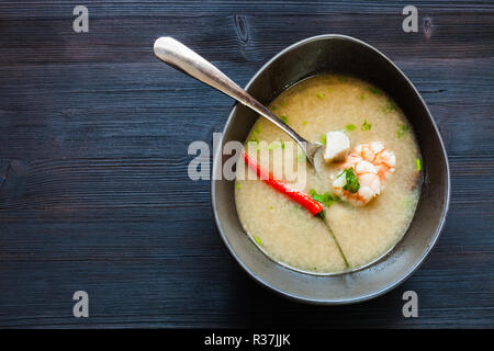 Thai cuisine dish - above view of bowl with Tom Kha Thale (Tom kha kai, Tom Kha Gai, Thai Coconut Soup) sour and spicy soup with shrimps and mushrooms Stock Photo