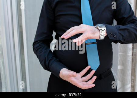 a businessman in a suit and tie with outstretched hand for implementation of graphic futuristic. Concept: business, graphic, holography, alpha channel Stock Photo