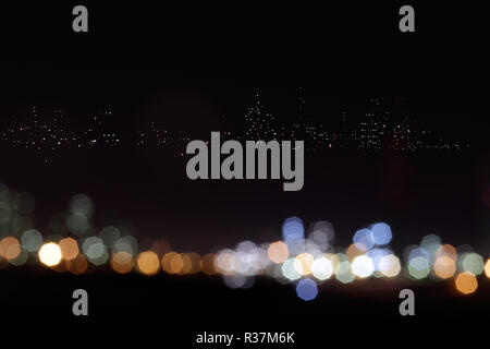 interesting image with colorful flares in the foreground and city distant lights in the background Stock Photo