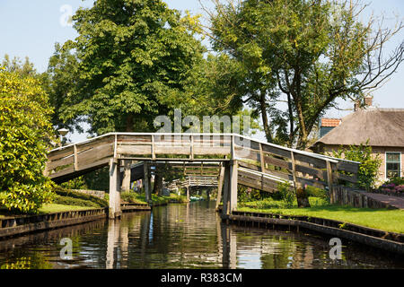 The thatched roof house with beatiful garden and wooden bridges in fairytale village Giethoorn in The Netherlands. Stock Photo