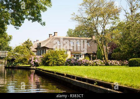 The thatched roof house with beatiful garden in fairy-tale village Giethoorn in The Netherlands. Stock Photo